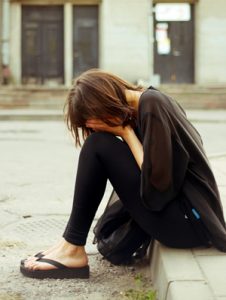 Upset Woman Sitting On the Sidewalk